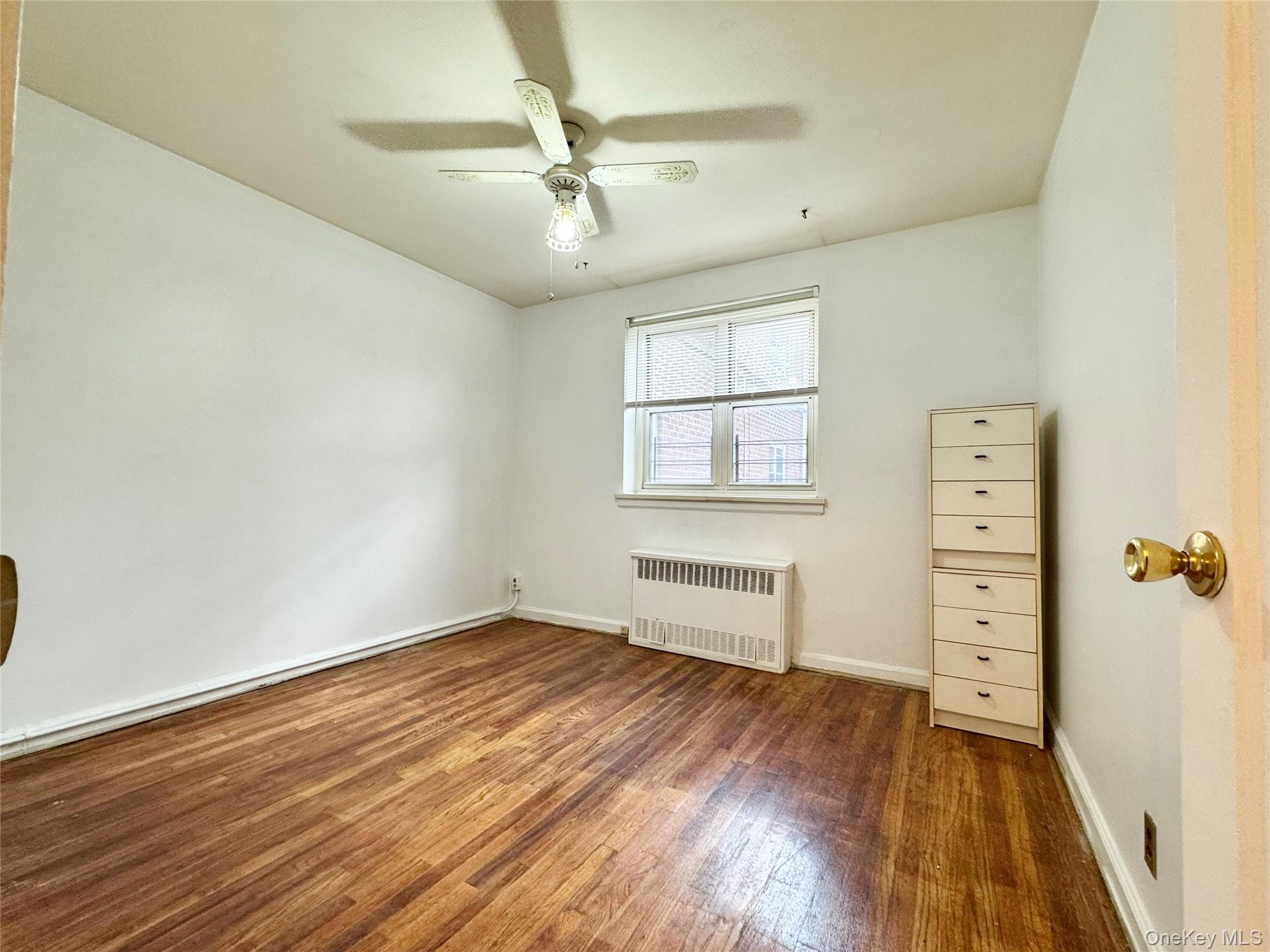 35-40 Clearview Expressway, Unit 371 Queens, NY 11361 - Photo 7 of 10 wooden floor in an empty room with a window