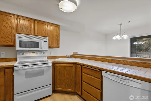 a kitchen with cabinets stainless steel appliances and wooden floor
