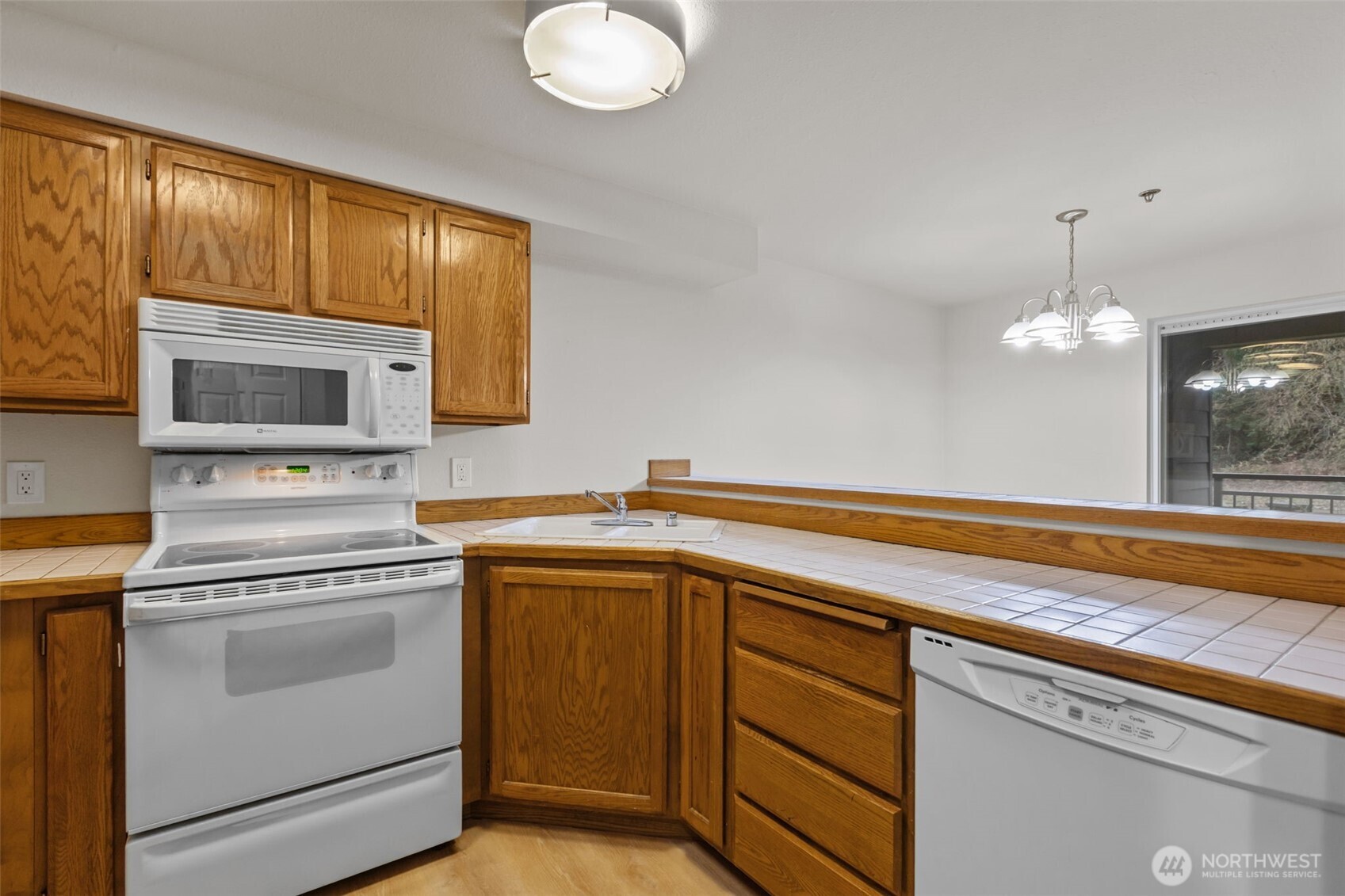 19404 Bothell Way Northeast, Unit B202 Bothell, WA 98011 - Photo 16 of 38 a kitchen with cabinets stainless steel appliances and wooden floor