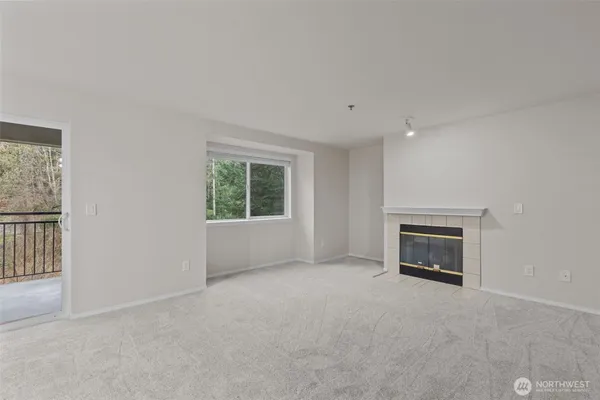 an empty room with a fireplace and windows
