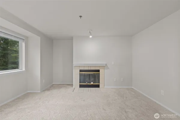 an empty room with a fireplace and window