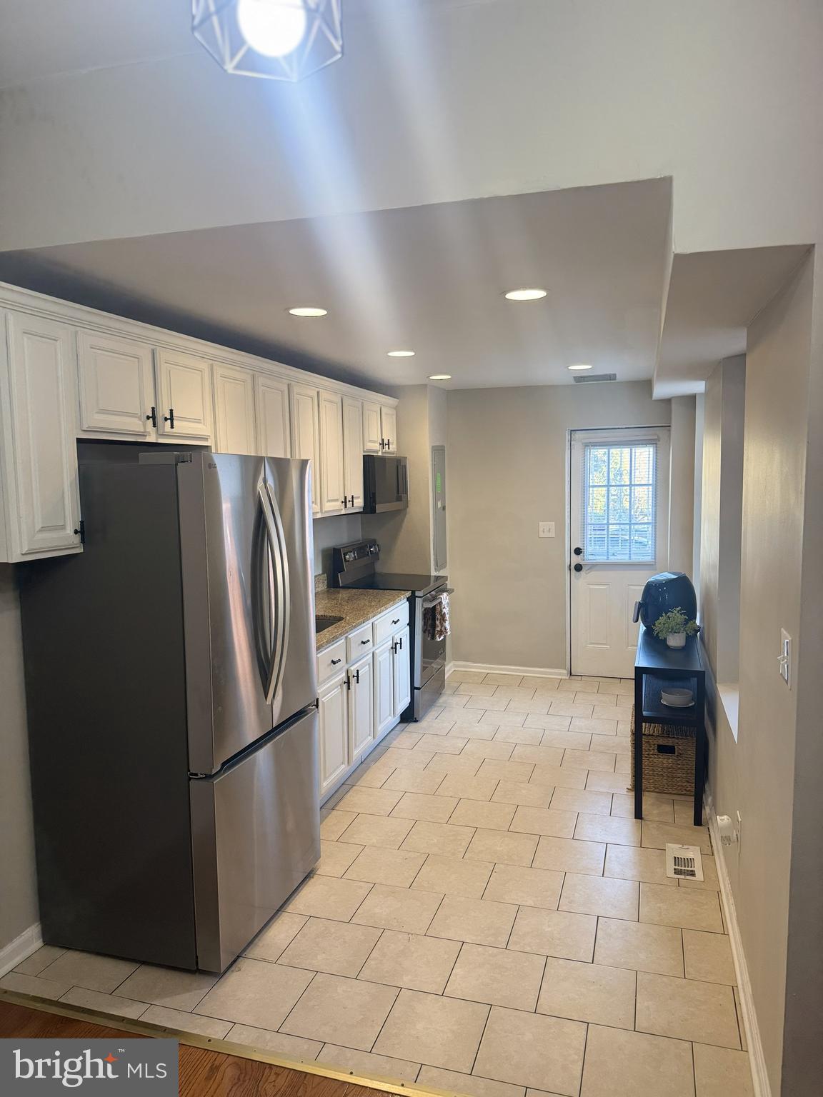 1235 North Bond Street Baltimore, MD 21213 - Photo 5 of 19 a kitchen with stainless steel appliances a refrigerator and a stove top oven