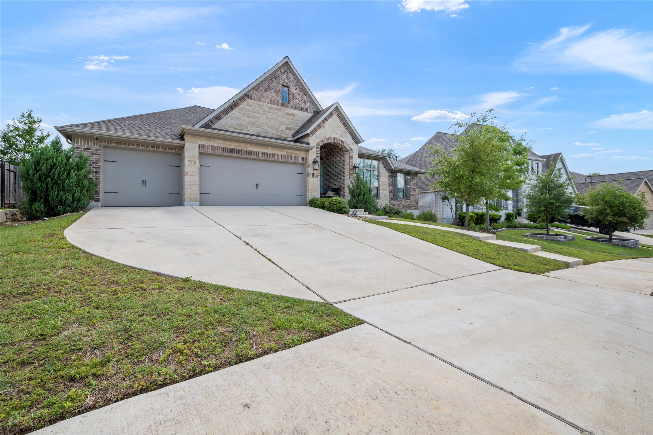 140 Catani Loop Georgetown, TX 78628 - Photo 2 of 36 A grand two-car garage complements this inviting home with stone and brick facade.