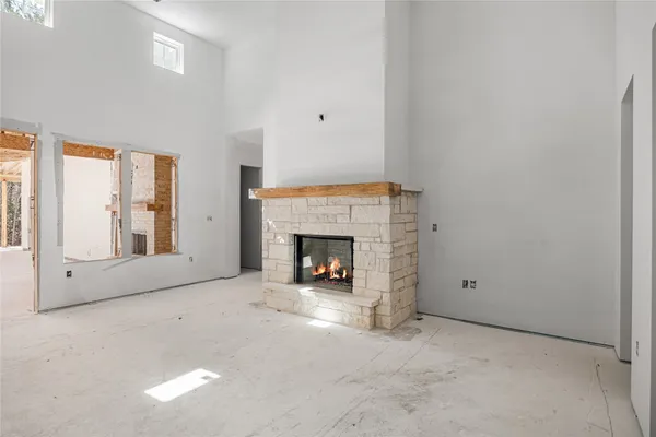 a view of an empty room with a fireplace and a window