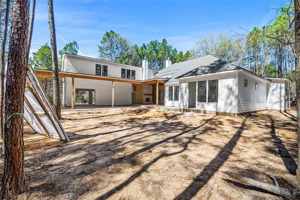 a backyard of a house with large trees and barbeque oven