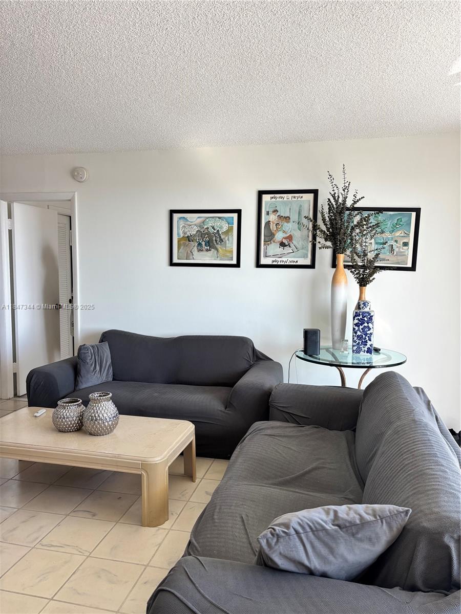 427 Golden Isles Drive, Unit 12B Hallandale Beach, FL 33009 - Photo 1 of 10 a living room with furniture and a couch