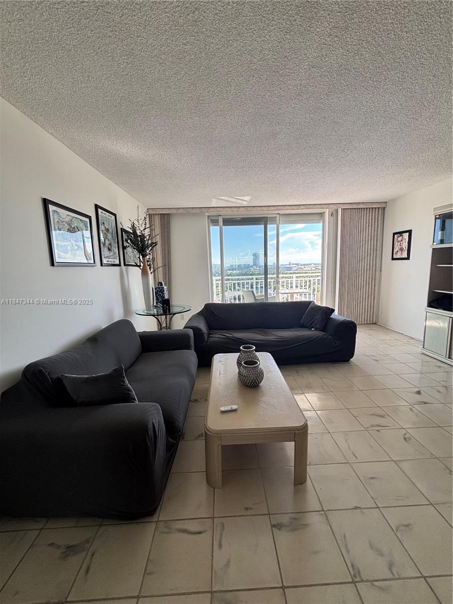 427 Golden Isles Drive, Unit 12B Hallandale Beach, FL 33009 - Photo 4 of 10 a living room with furniture and a window