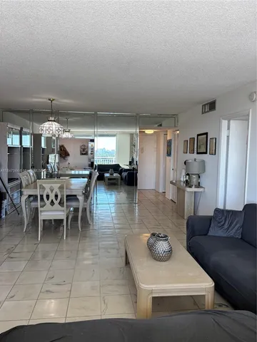 a living room with furniture and a view of kitchen