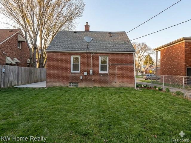 4607 Cadieux Road Detroit, MI 48224 - Photo 15 of 18 Back of property with a fenced backyard, a chimney, brick siding, and roof with shingles