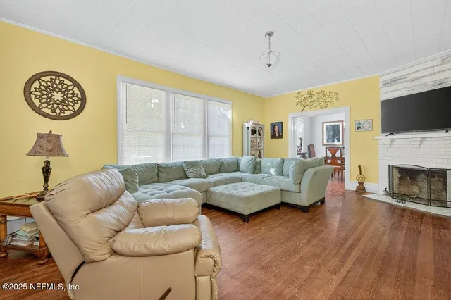 a living room with furniture a flat screen tv and a fireplace