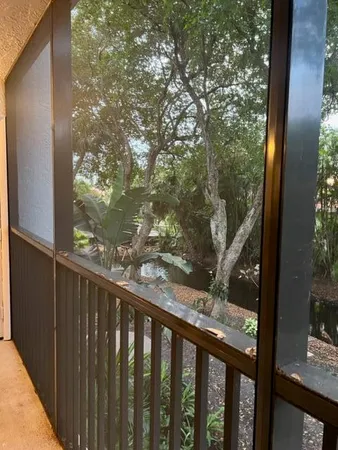a balcony with wooden floor and yard