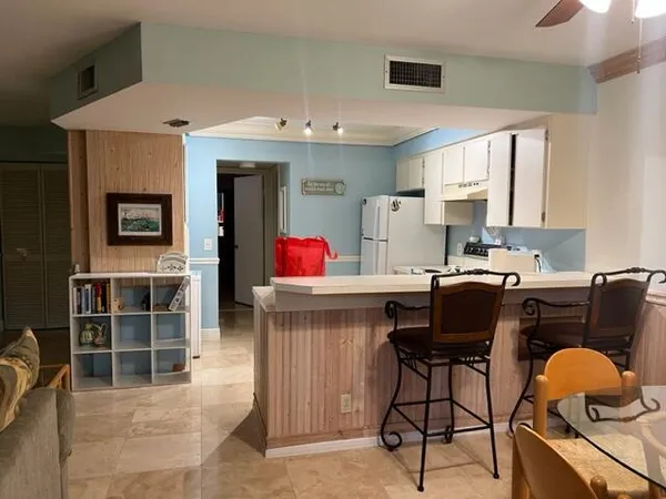 a living room with furniture a window and kitchen view