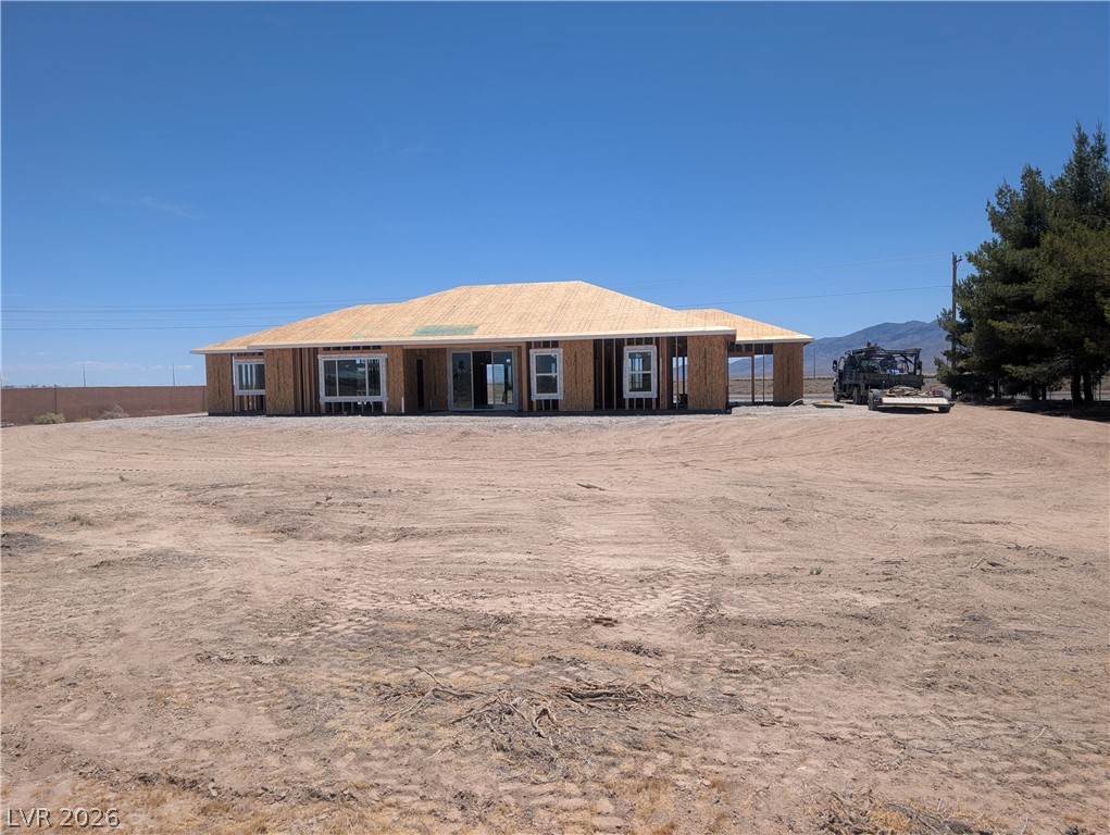 1120 West Gamebird Road Pahrump, NV 89048 - Photo 3 of 36 A newly framed single-story home awaits its finishing touches under a vast, open sky.