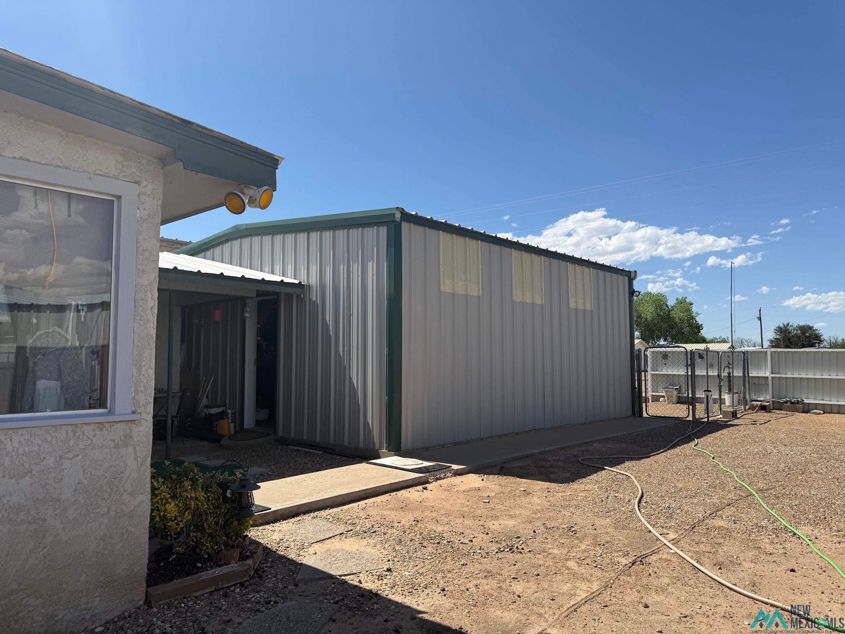 4010 540th Loop Logan, NM 88426 - Photo 35 of 38 Galvanized steel structure featuring a green metal trim roofline and multiple translucent wall panels