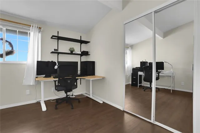 a view of a workspace with furniture and a window