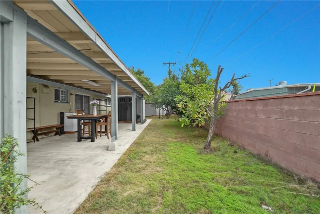 a view of a backyard with table and chairs and potted plants