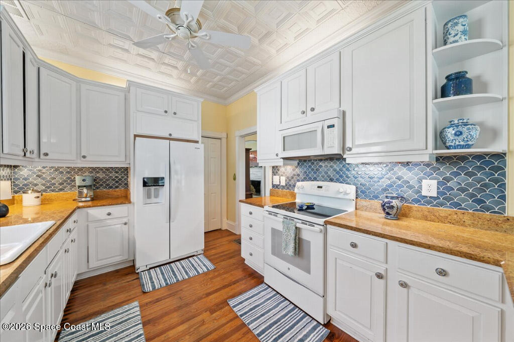 1110 Riverside Drive Titusville, FL 32780 - Photo 16 of 50 a kitchen with white cabinets and white appliances
