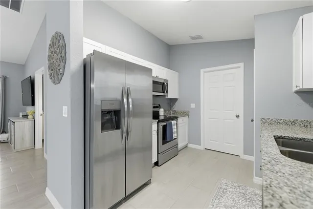 a kitchen with stainless steel appliances granite countertop a refrigerator and a sink