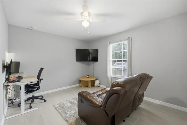 a living room with furniture a flat screen tv and a window