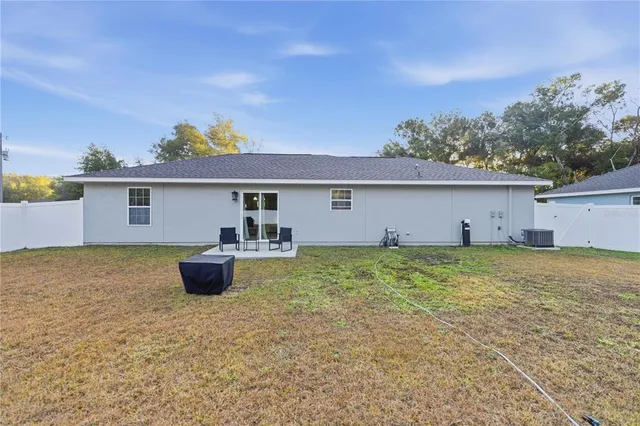 a view of a house with a backyard and a tree