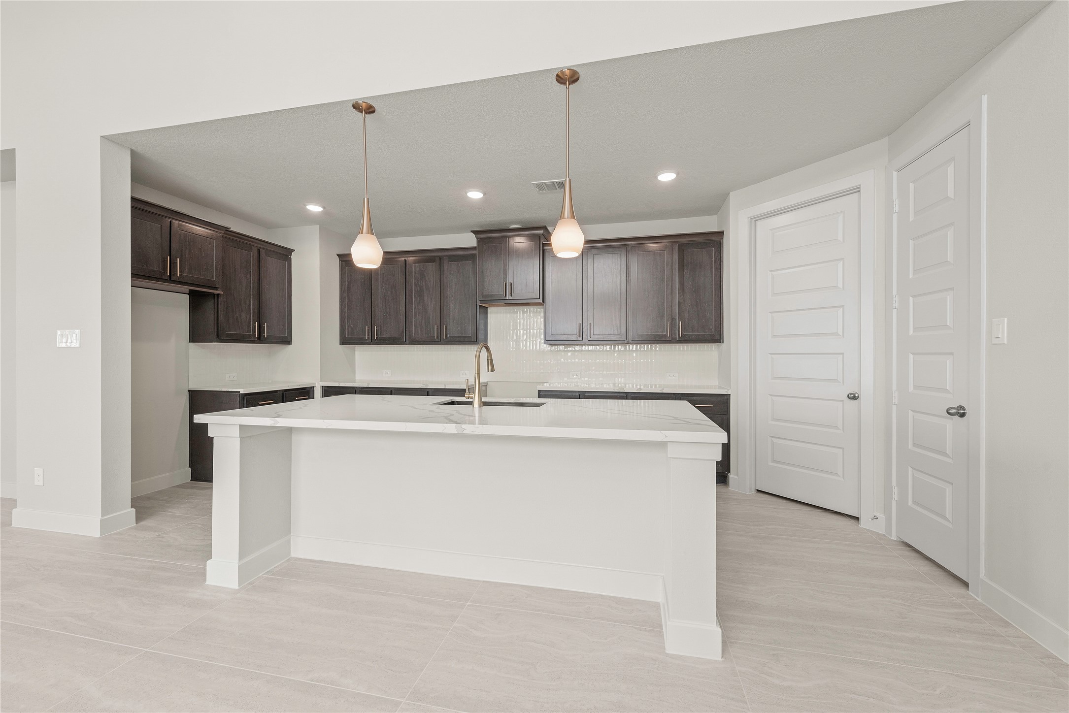 4403 Ruby Gdn Court Fulshear, TX 77441 - Photo 6 of 28 a large kitchen with a large counter top a sink stainless steel appliances and cabinets