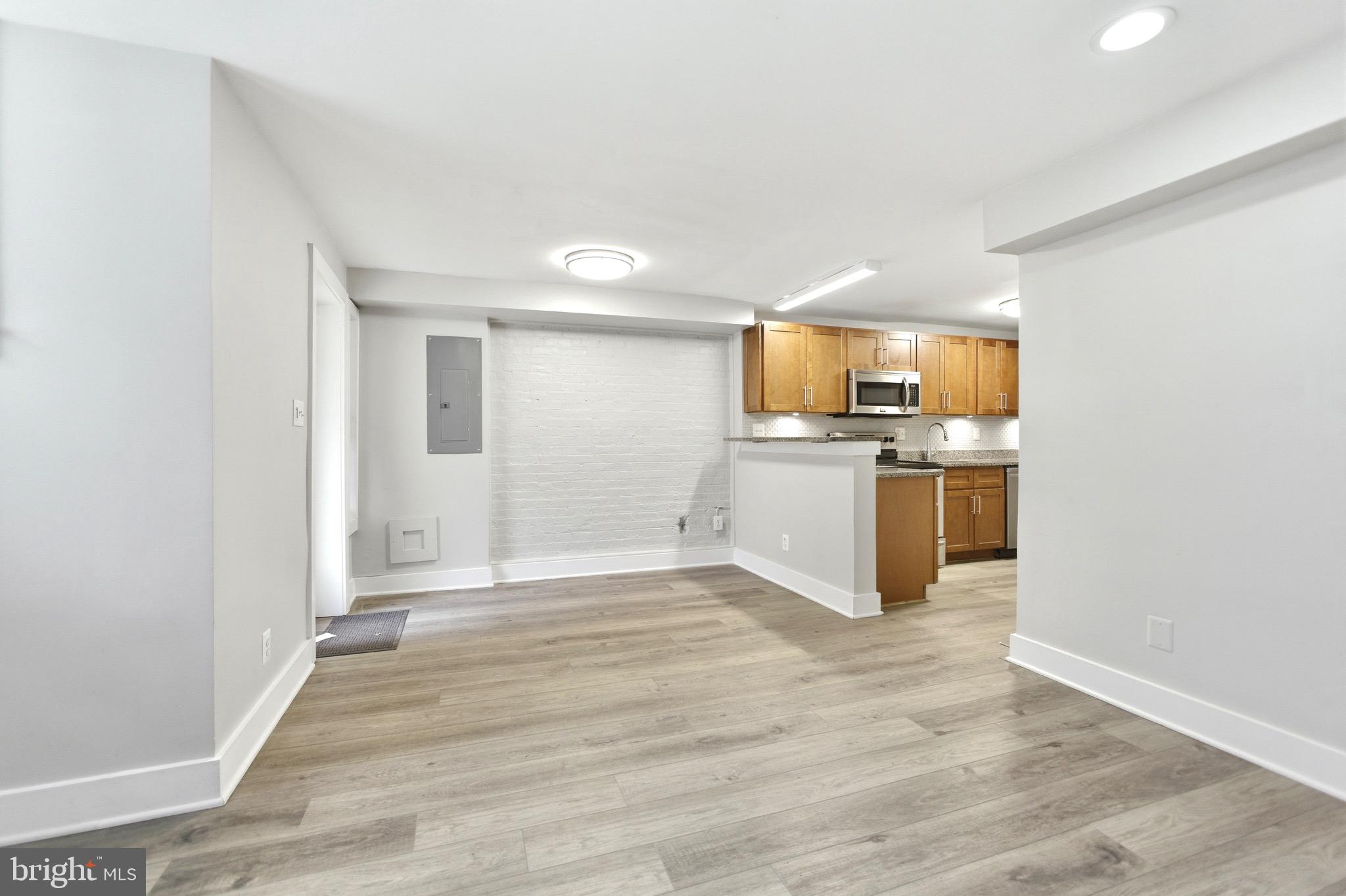a view of a kitchen with a sink stove cabinets and empty room