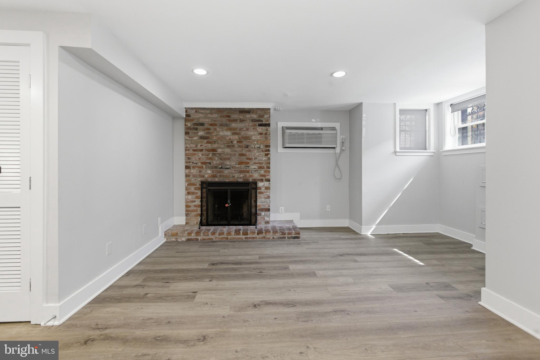 1451 Harvard Street Northwest, Unit 1 Washington, DC 20009 - Photo 3 of 24 a view of an empty room with wooden floor fireplace and a window