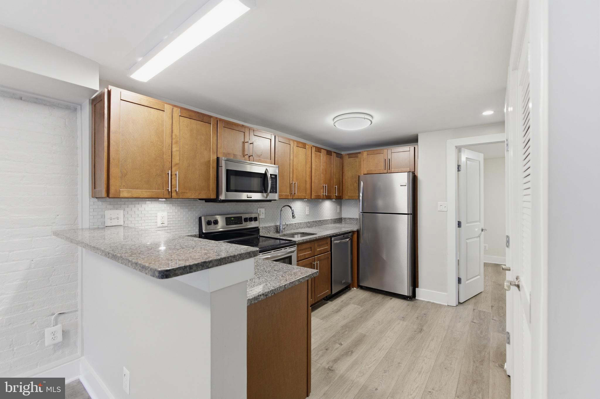 1451 Harvard Street Northwest, Unit 1 Washington, DC 20009 - Photo 7 of 24 a kitchen with a refrigerator stove microwave and sink