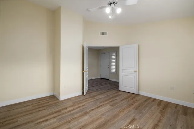 an empty room with wooden floor and windows