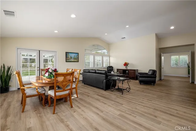 a living room with furniture a wooden floor and a flat screen tv