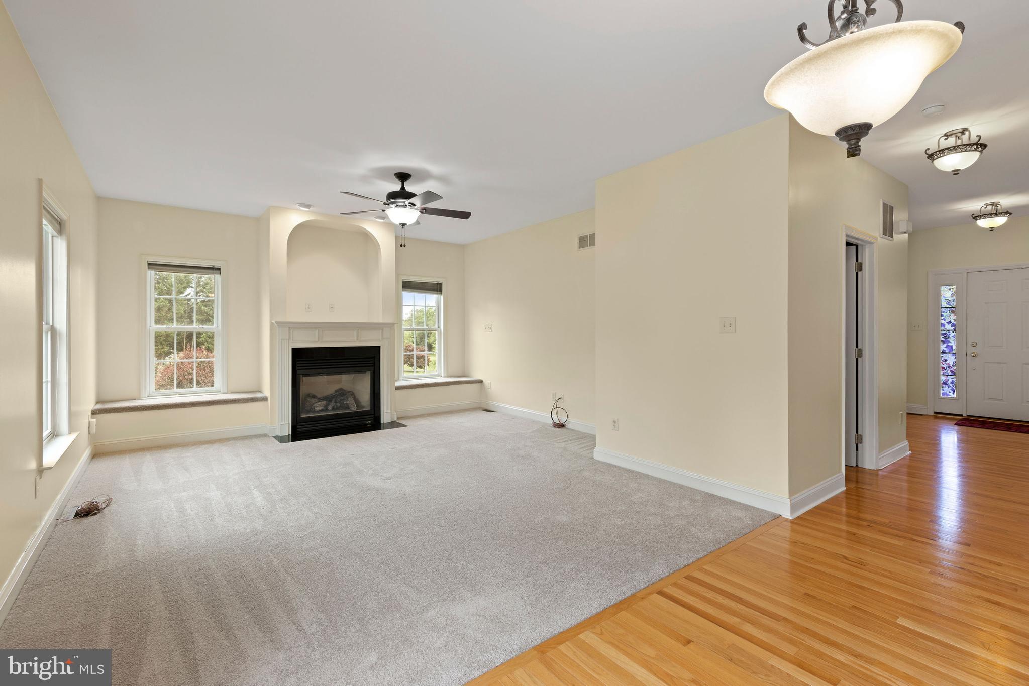 67 Merry Knoll Court Conowingo, MD 21918 - Photo 13 of 50 an empty room with a fireplace and wooden floor