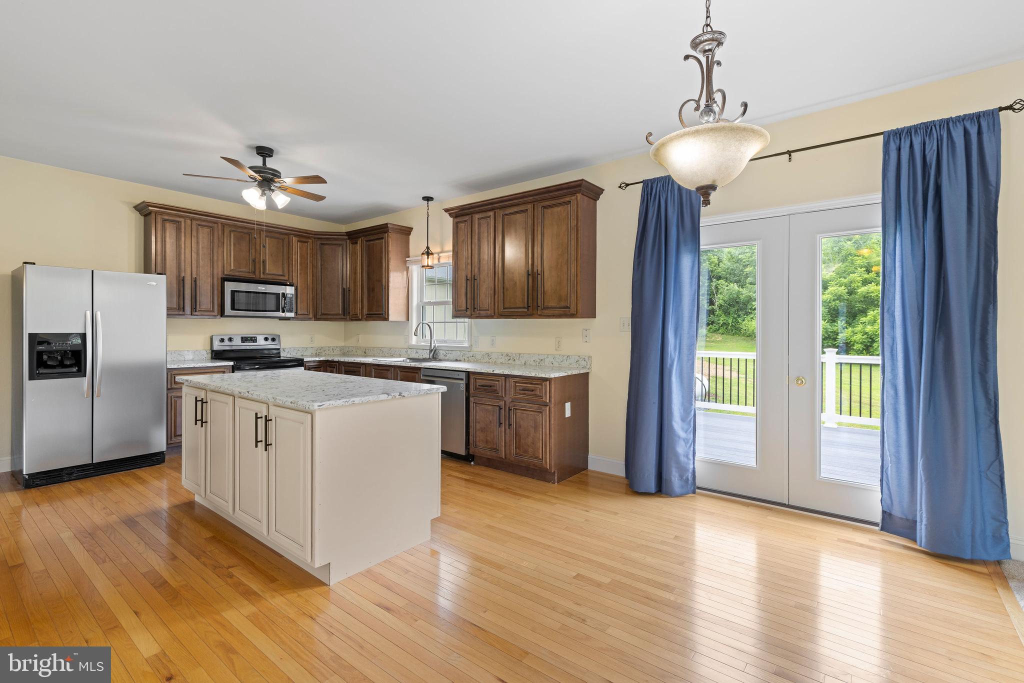 67 Merry Knoll Court Conowingo, MD 21918 - Photo 7 of 50 a kitchen with granite countertop a stove top oven a refrigerator cabinets and wooden floor