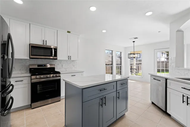 a kitchen with white cabinets stainless steel appliances and a sink