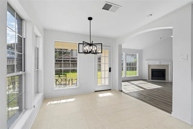 a view of an empty room with a fireplace and a window