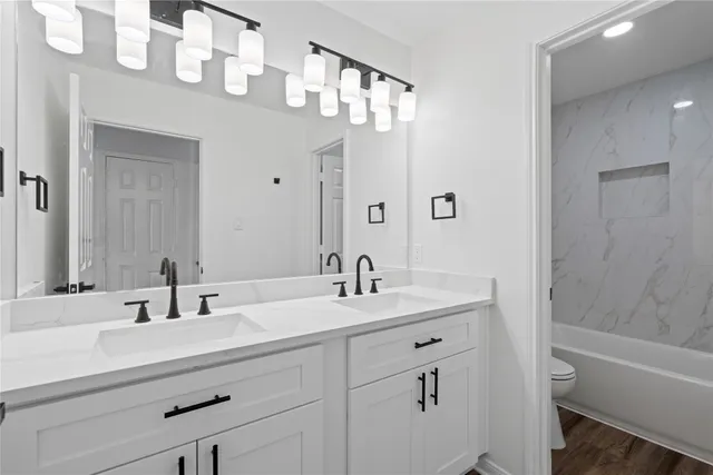 a bathroom with a sink vanity tub and shower