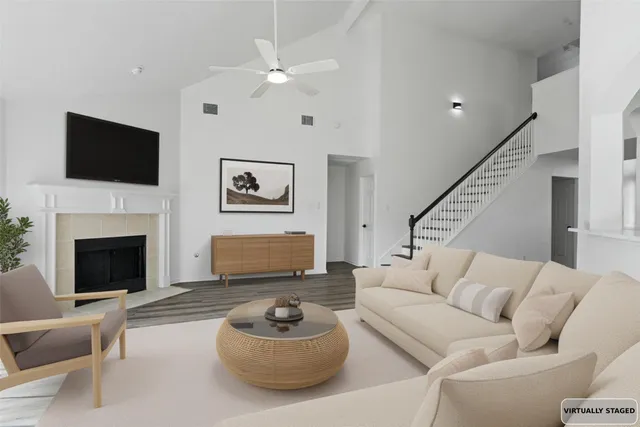 a living room with furniture a fireplace and a flat screen tv