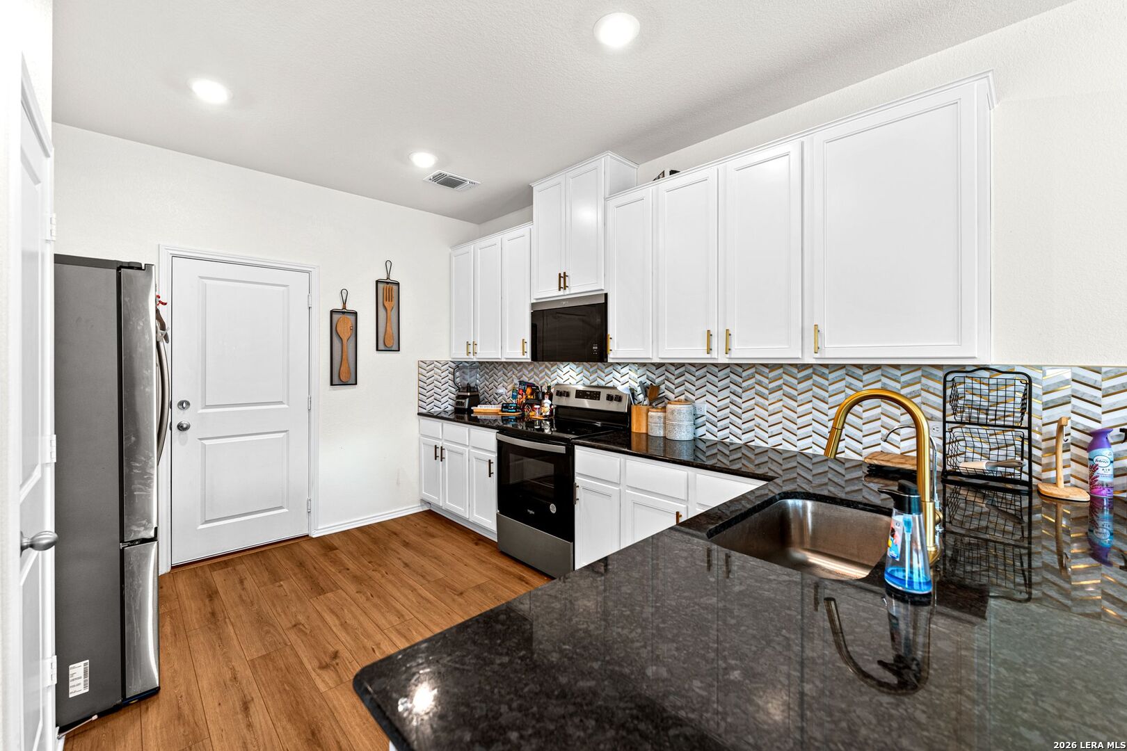 1029 Santiam Street Georgetown, TX 78626 - Photo 11 of 37 a kitchen with granite countertop a refrigerator and a stove top oven