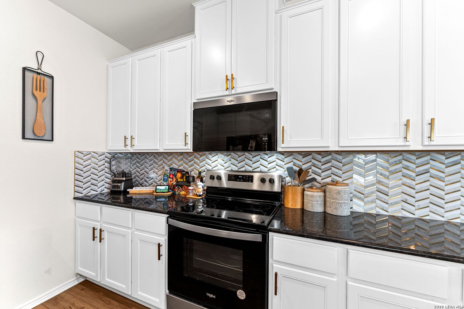 1029 Santiam Street Georgetown, TX 78626 - Photo 13 of 37 a kitchen with stainless steel appliances granite countertop white cabinets and black appliances