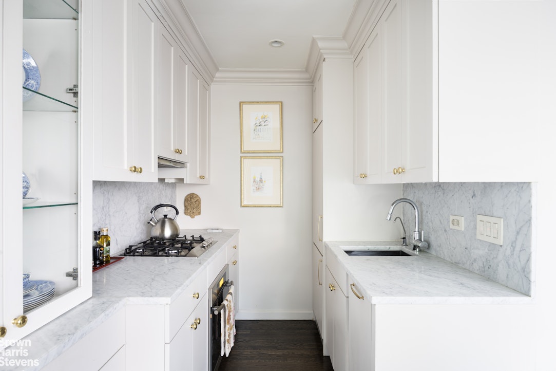 342 East 53rd Street, Unit 2GH Manhattan, NY 10022 - Photo 4 of 9 a kitchen with stainless steel appliances granite countertop a sink stove and cabinets