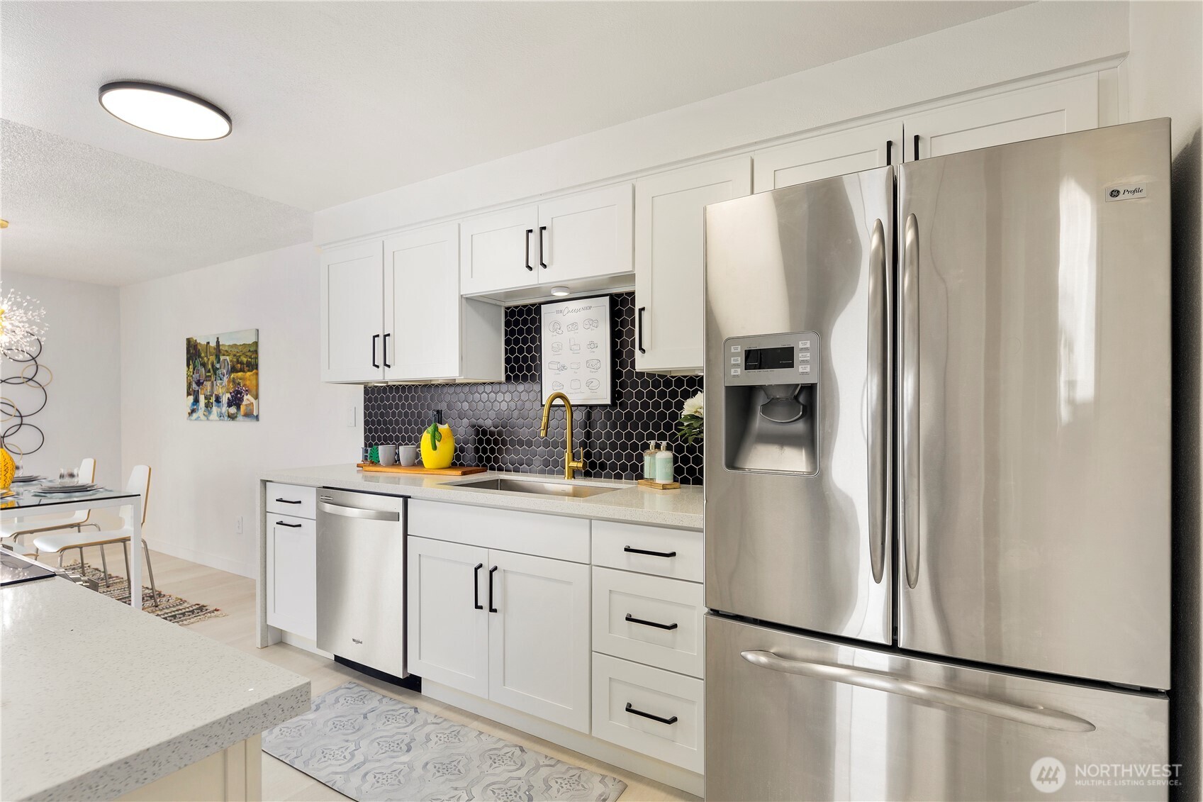22532 6th Avenue South, Unit A2 Seattle, WA 98198 - Photo 13 of 35 a kitchen with stainless steel appliances a refrigerator sink and white cabinets