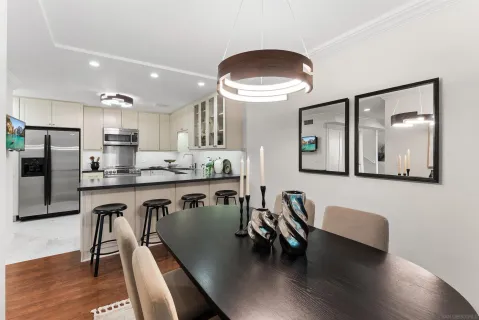 a very nice looking dining room with kitchen island stainless steel appliances refrigerator dining table and chairs