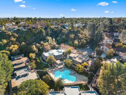 an aerial view of residential houses with outdoor space and trees