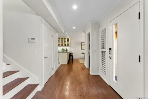 a view of a hallway with wooden floor and closet