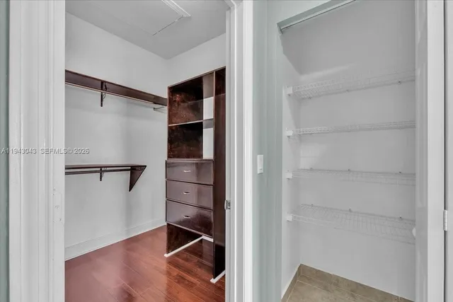 a room with walk in closet and wooden floor