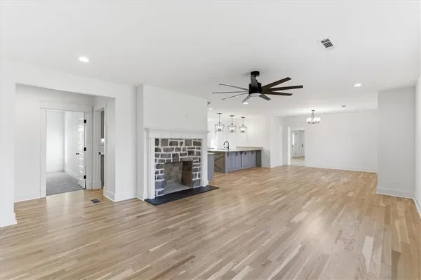 a view of empty room with wooden floor and ceiling fan