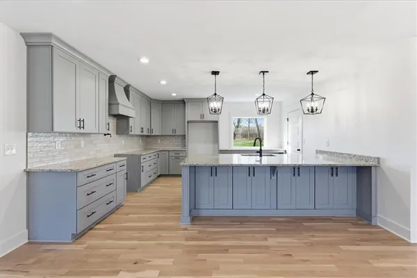 a kitchen with stainless steel appliances granite countertop a sink and dishwasher with wooden floor
