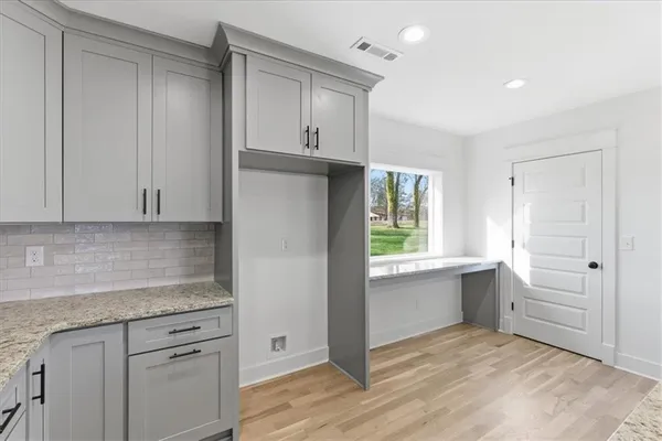 a kitchen with a sink and dishwasher with white cabinets