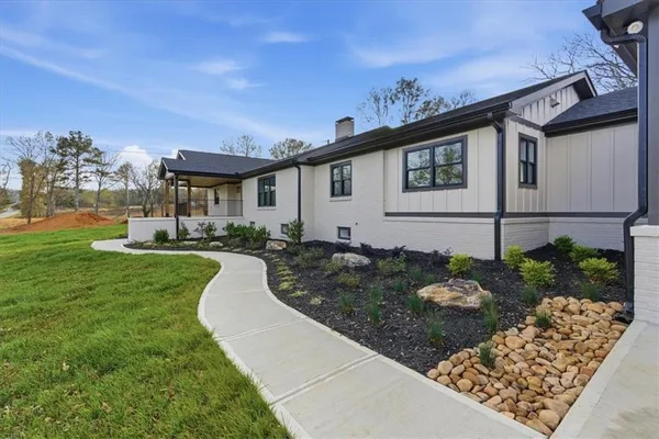 a view of a house with backyard and sitting area