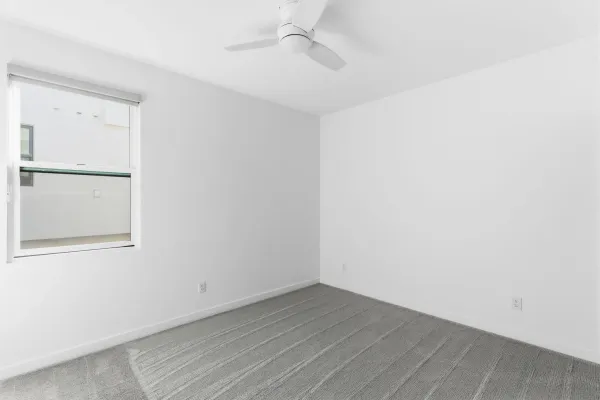 an empty room with a window and wooden floor