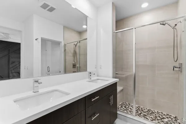 a bathroom with a double vanity sink a mirror and shower